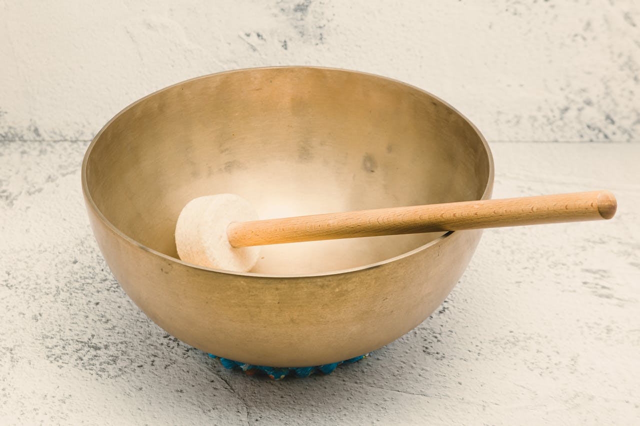 A serene image of a Tibetan singing bowl accompanied by a wooden mallet, perfect for meditation and relaxation.